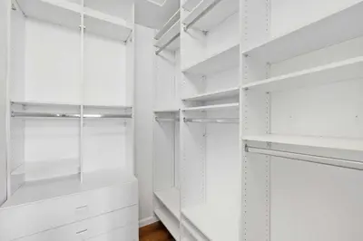 a white walk in closet with white shelves at Spacious home wpool tennis court in Sunrise