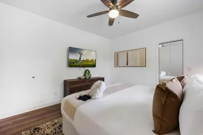 a white bedroom with a bed and a ceiling fan at Spacious home wpool tennis court in Sunrise
