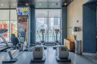a gym with cardio equipment and a large window at 1BR on Miami Beach with Beach Service & Near Mall in Hallandale Beach