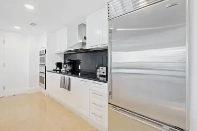 a kitchen with white cabinets and a stainless steel refrigerator at Ritz-Carlton Luxury Oceanview 3-Bedroom Residence in Fort Lauderdale