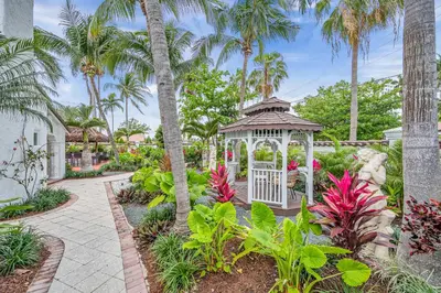 a gazebo in a garden with palm trees at Grand historic Residence Walk to beach Heated Pool Outdoor kitchen Hibiscus Key Residences in Fort Lauderdale