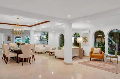 a dining room and living room with a table and chairs at Grand historic Residence Walk to beach Heated Pool Outdoor kitchen Hibiscus Key Residences in Fort Lauderdale