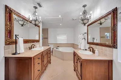 a bathroom with two sinks and a tub and a mirror at Grand historic Residence Walk to beach Heated Pool Outdoor kitchen Hibiscus Key Residences in Fort Lauderdale