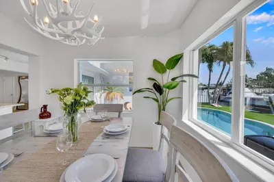a dining room with a table and a large window at Waterfront Bungalow Heated Pool Pineapple Key in Fort Lauderdale