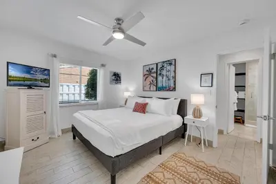 a white bedroom with a bed and a window at Waterfront Bungalow Heated Pool Pineapple Key in Fort Lauderdale