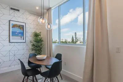 a dining room with a table and chairs and a window at Apto Moderno a 5min da Praia em South Beach in Miami Beach