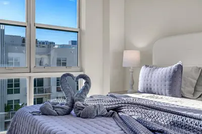 two towel swans sitting on a bed in a bedroom at Luxury 2BR with City Views on Biscayne Blvd in Miami
