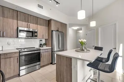 a kitchen with wooden cabinets and a white counter top at Luxury 2BR with City Views on Biscayne Blvd in Miami