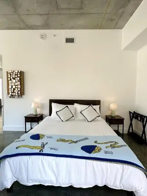 a bedroom with a bed with a blue and white bedspread at Pop Art Sunlit Apartment Prime Miami Pool Free Parking in Miami