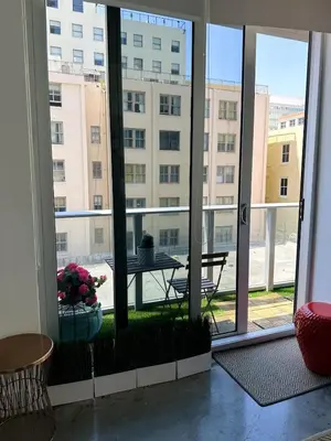a room with a large window with a table and a building at Pop Art Sunlit Apartment Prime Miami Pool Free Parking in Miami