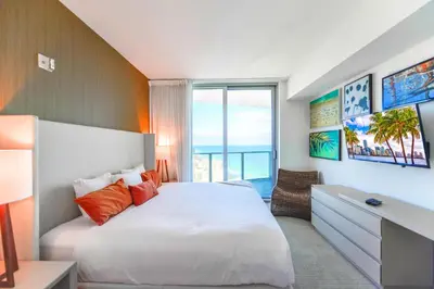 a bedroom with a bed and a desk and a window at Live The Perfect Vacations in a Condo From The High in Hollywood