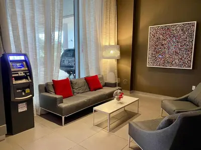 a living room with a couch and a slot machine at Trendy Miami Apartment Walk to the Beach in Hallandale Beach