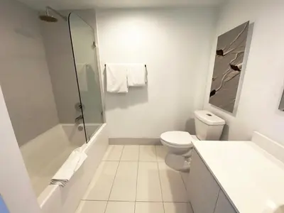 a white bathroom with a toilet and a shower at Beach, pool, and Gym 2B 2B Near Gulfstream & Mall in Hallandale Beach