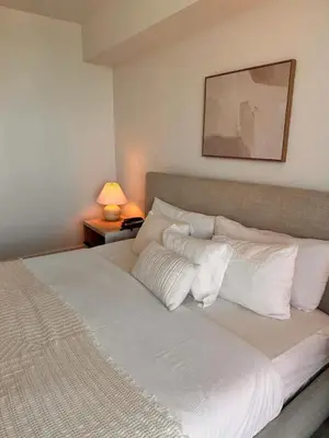a bed with white pillows and a picture on the wall at 1BR 1BA with Pool & Sun in Miami Beach in Hallandale Beach