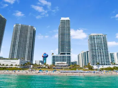 a beach in front of a city with tall buildings at Stylish Condo Steps From the Beach! in Hollywood