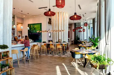 a restaurant with tables and chairs and a bar at Stylish Condo Steps From the Beach! in Hollywood