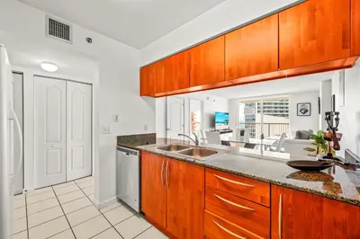 a kitchen with wooden cabinets and a sink at Sky High Living with Incredible Views in Miami