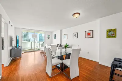 a dining room with a table and white chairs at Sky High Living with Incredible Views in Miami