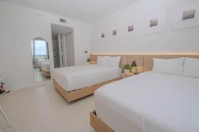two beds in a white room with a mirror at Perfect getaway beach pool and Aventura Mall 2209 in Hallandale Beach