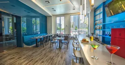 a restaurant with a bar with tables and chairs at Perfect getaway beach pool and Aventura Mall 2209 in Hallandale Beach
