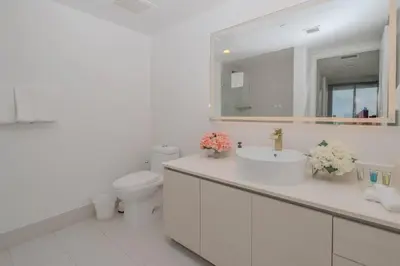 a bathroom with a sink and a toilet and a mirror at Enjoy Miami 2B 2B pool beach and Aventura Mall in Hallandale Beach