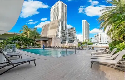 a swimming pool with chaise lounge chairs and buildings at Enjoy Miami 2B 2B pool beach and Aventura Mall in Hallandale Beach