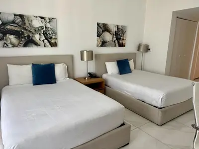 two beds in a hotel room with blue pillows at Getaway in Miami 2B 2B beachfront near Aventura 3003 in Hallandale Beach