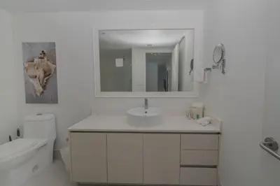 a white bathroom with a sink and a mirror at Your Paradise in Miami Beach Gym and Pool 2b 2b 1507 in Hallandale Beach