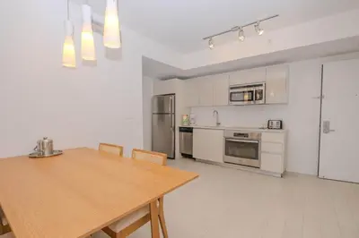 a kitchen with a wooden table and a kitchen with appliances at Miami Apt with Gym Beach Service Pool on the water 2607 in Hallandale Beach