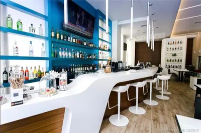 a bar with a white counter and bar stools at Beach Apt with Full kitchen and King size bed in Hallandale Beach