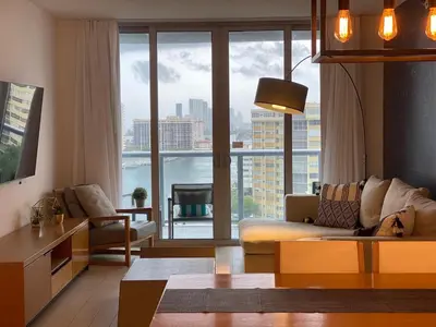 a living room with a couch and a large window at Charming 2 Bedroom Apt with Pool & Beach Service 2808 in Hallandale Beach