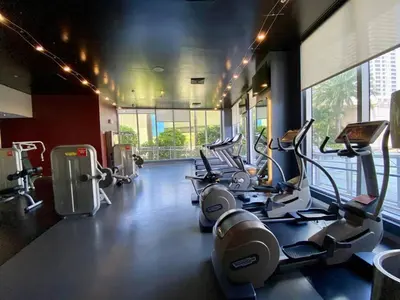 a gym with cardio machines and a large window at Charming 2 Bedroom Apt with Pool & Beach Service 2808 in Hallandale Beach