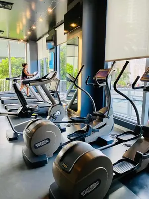 a woman sitting on a treadmill in a gym at 2610 Enjoy Miami 2B 2B, Pool, Beach & Mall in Hallandale Beach