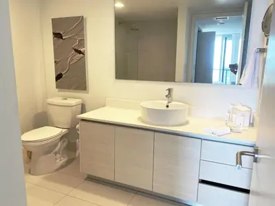 a bathroom with a sink and a toilet and a mirror at 2610 Enjoy Miami 2B 2B, Pool, Beach & Mall in Hallandale Beach