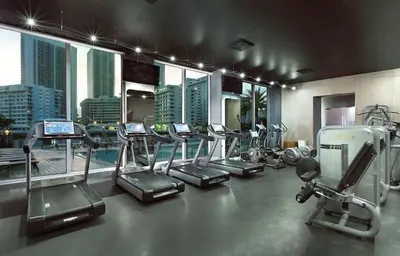 a gym with a bunch of treadms and elliptical machines at Luxury Miami Apartment Beach and Poolside drinks 2308 in Hallandale Beach