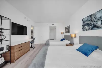 a bedroom with two beds and a flat screen tv at Suite with Beach Serv Pool and close to Aventura Mall 2808 in Hallandale Beach