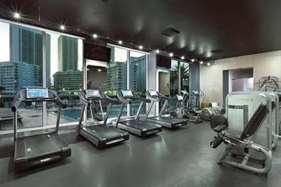 a gym with treadmills and ellipticals in a building at Suite with Beach Serv Pool and close to Aventura Mall 2808 in Hallandale Beach