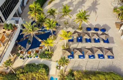 an aerial view of a resort with palm trees and blue umbrellas at 2b 2b Apmt Hallandale Beach 2805 in Hallandale Beach