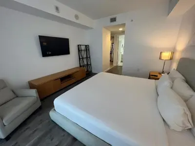 a bedroom with a large white bed and a couch at Miami Beautiful with kitchen, pool and mall Apmt 1B 1B 1408 in Hallandale Beach