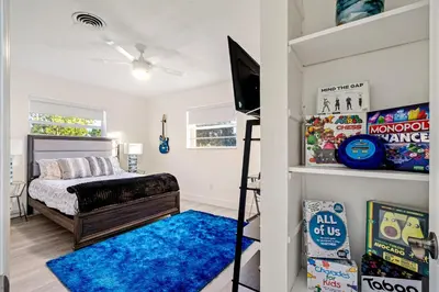 a bedroom with a bunk bed and a blue rug at Sleeps 12 Private Pool & Gameroom near Casino, Beaches & Hard Rock Stadium in Hollywood