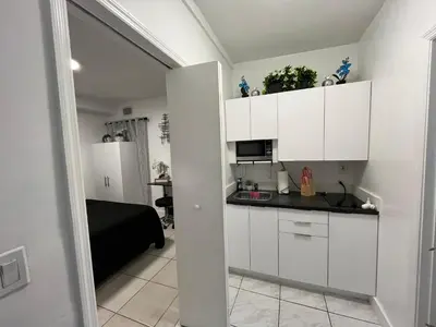 a kitchen with white cabinets and a black counter top at Guest Suite w free parking at 7 min to Miami international airport in Miami