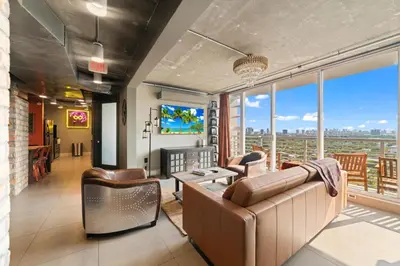 a living room with a couch and a tv at Hollywood Beach Speakeasy Condo in Hollywood