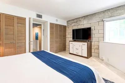 a bedroom with a large bed and a flat screen tv at Piano House on the Water in Fort Lauderdale