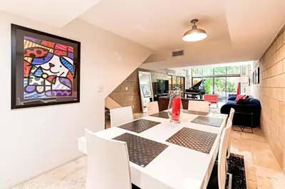 a dining room with a white table and chairs at Piano House on the Water in Fort Lauderdale
