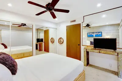 a bedroom with a bed and a flat screen tv at Singer House on the Water in Fort Lauderdale