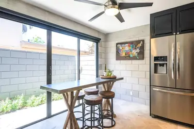 a kitchen with a table and a refrigerator at Singer House on the Water in Fort Lauderdale
