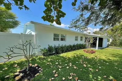 a white house with a green yard at Chic 3BR 2BA Getaway with Private Pool Oasis in Fort Lauderdale