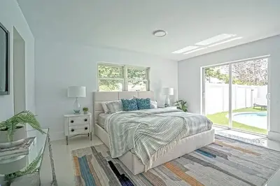 a white bedroom with a bed and a window at Chic 3BR 2BA Getaway with Private Pool Oasis in Fort Lauderdale