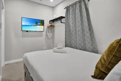 a bedroom with a bed and a tv on a wall at Miami Flats - Self Check-in and 1 Free Parking in Miami