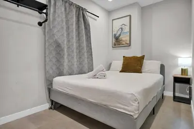a bedroom with a large bed with white sheets and a window at Miami Flats - Self Check-in and 1 Free Parking in Miami